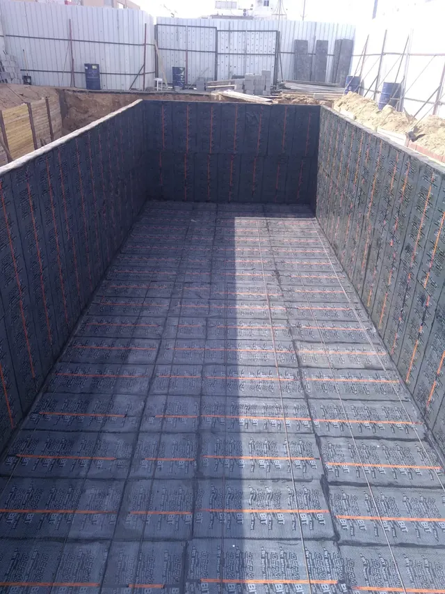 Open concrete tank with insulation boards fitted on its walls and floor
